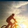 In copertina una persone conduce una bicicletta mentre il sole tramonta.