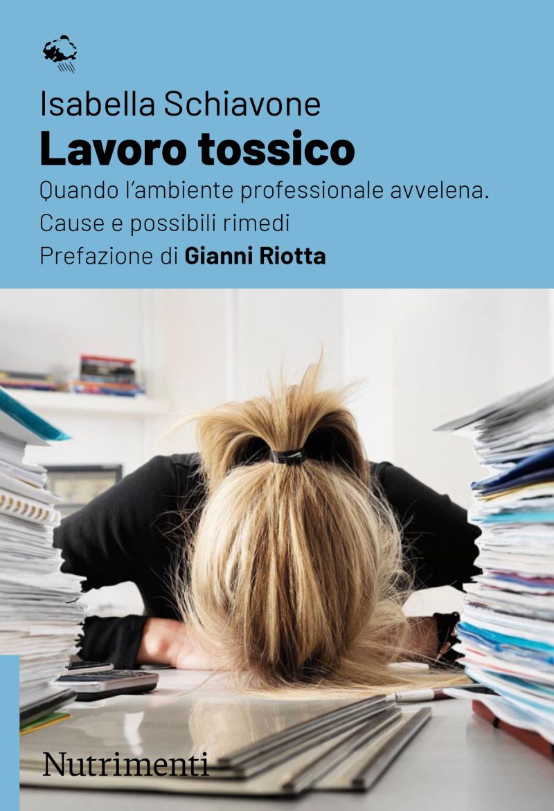 In copertina giovane donna poggia la testa sulla scrivania tra cumuli di documenti.
